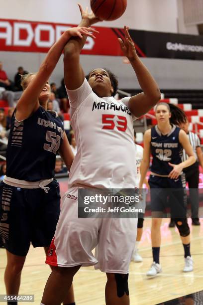 Bernadette Fong of the Cal State Northridge Matadors is fouled as she shoots against Ingrida Strikas of the Utah State Aggies in the Consolation Game...