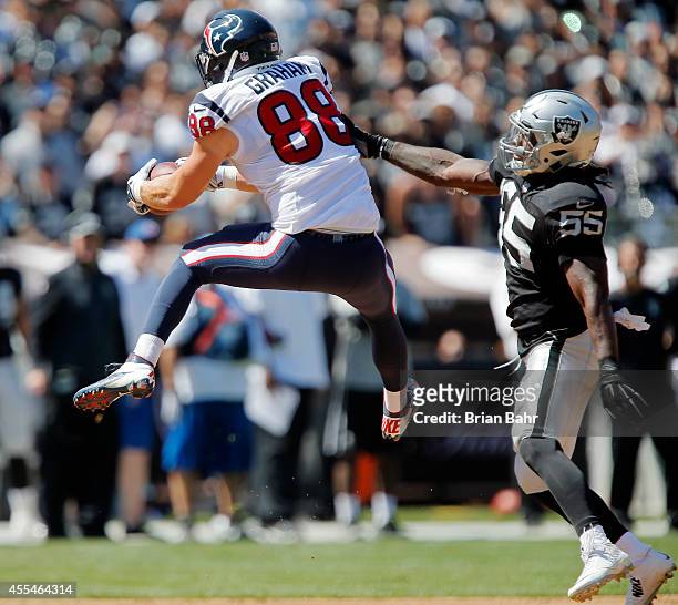 Tight end Garrett Graham of the Houston Texans hauls in a pass against linebacker Sio Moore of the Oakland Raiders in the first quarter on September...
