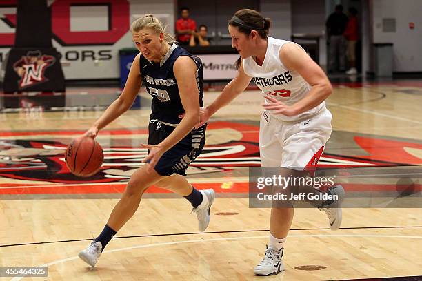 Ingrida Strikas of the Utah State Aggies drives against Mikayla Thielges of the Cal State Northridge Matadors in the Consolation Game of the Radisson...