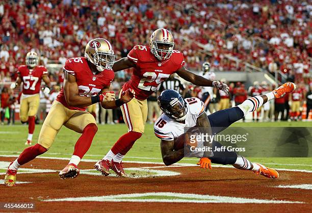 Wide receiver Brandon Marshall of the Chicago Bears catches a pass for a touchdown while defended by free safety Eric Reid and strong safety Jimmie...