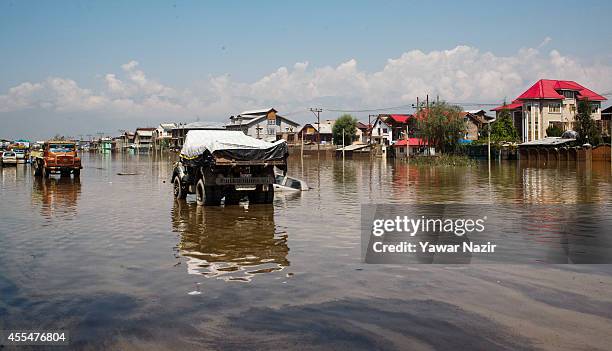 Vehicles that were left by sit on a submerged highway in the flooded Bemina area on September 15, 2014 in Srinagar, the summer capital of Indian...