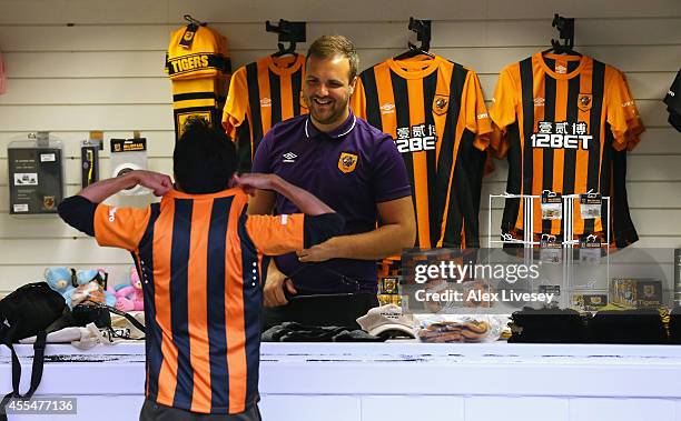 Supporter of Hull City buys a replica shirt at a souvenir shop prior to the Barclays Premier League match between Hull City and West Ham United at KC...