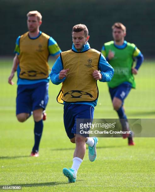 Jack Wilshere warms up during a Arsenal Training Session ahead of their Champions League fixture against Borussia Dortmund on September 15, 2014 in...