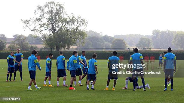 The Arsenal team warm up during a Arsenal Training Session ahead of their Champions League fixture against Borussia Dortmund on September 15, 2014 in...