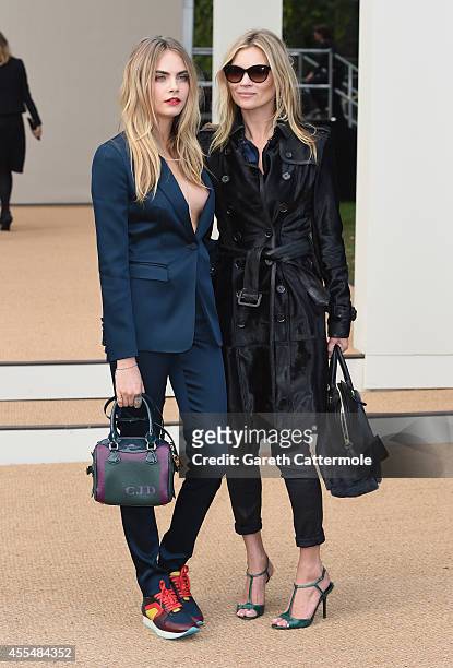 Cara Delevingne and Kate Moss attend the Burberry Womenswear SS15 show during London Fashion Week at Kensington Gardens on September 15, 2014 in...
