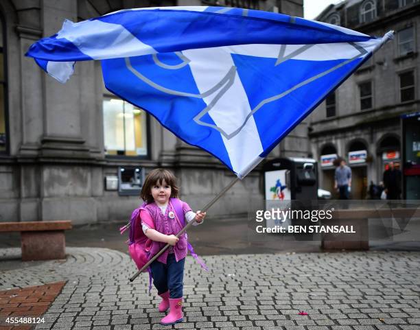 Child plays with a pro-independence 'Yes' flag on the streets of Aberdeen in Scotland, on September 15 ahead of the referendum on Scotland's...
