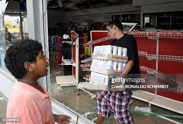 People loot a supermarket in Cabo San Lucas on September 15, 2014 after hurricane Odile knocked down trees and power lines in Mexico's Baja...