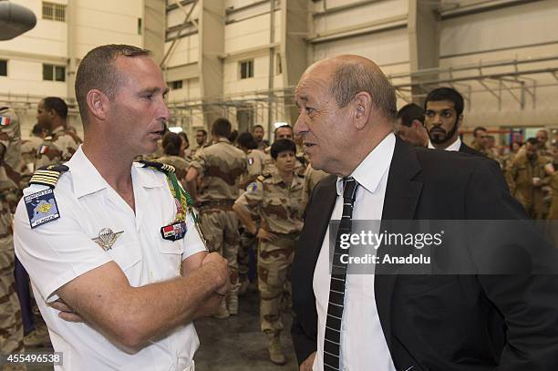 French Defense Minister Jean-Yves Le Drian talks with soldiers upon his visit to Al Dhafra Air Base in Abu Dhabi, United Arab Emirates on September...