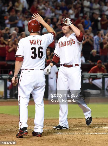 Mark Trumbo of the Arizona Diamondbacks and teammate Wade Miley celebrate a third inning grand slam against the San Francisco Giants at Chase Field...