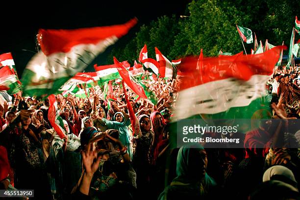 Female supporters cheer and wave Pakistan Awami Tehreek flags as Islamic cleric Muhammad Tahir-ul-Qadri, unseen, speaks during a rally at an...