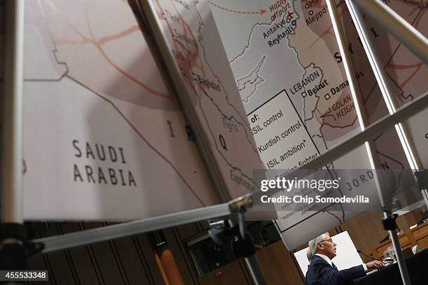 Framed by maps titled 'ISIL Ambition,' U.S. Defense Secretary Chuck Hagel testifies before the Senate Armed Services Committee in the Hart Senate...