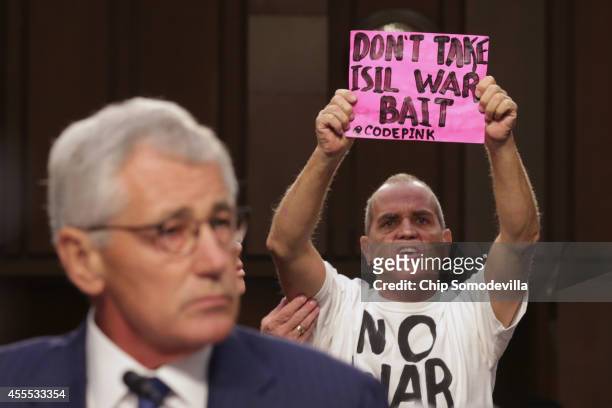 Code Pink for Peace member Tighe Barry protests against U.S. Military action in Iraq as Defense Secretary Chuck Hagel testifies before the Senate...
