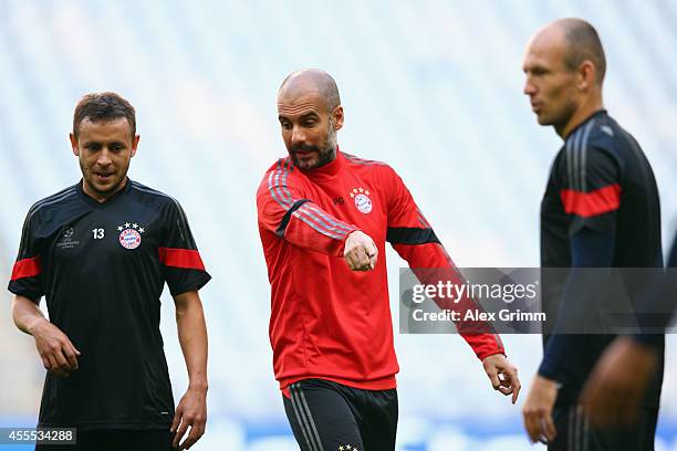 Head coach Pep Guardiola talks to Rafinha and Arjen Robben during the FC Bayern Muenchen training session ahead of their UEFA Champions League Group...