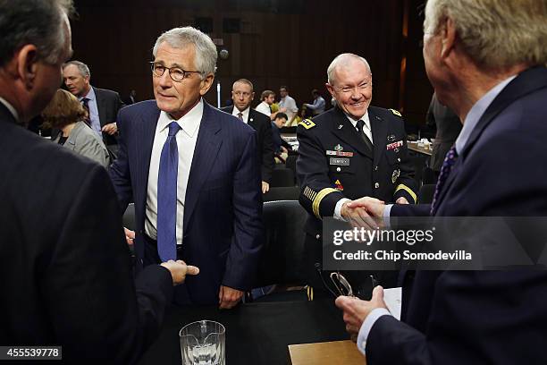 Defense Secretary Chuck Hagel and Chairman of the Joint Chiefs of Staff Army Gen. Martin Dempsey talk with Senate Armed Services Committee members...