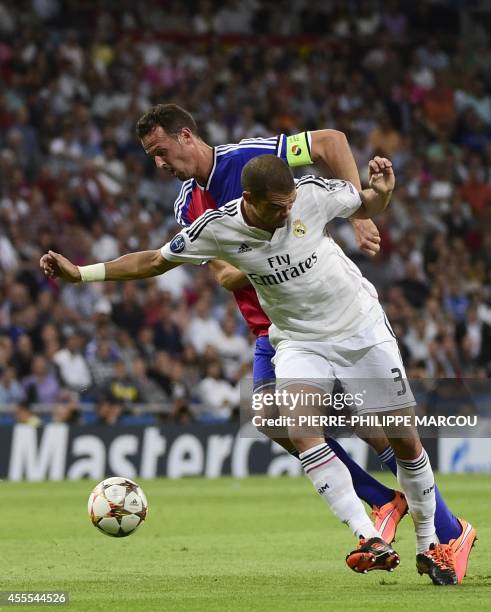 Real Madrid's Portuguese defender Pepe vies with Basel's forward Marco Streller during the UEFA Champions League football match Real Madrid CF vs FC...