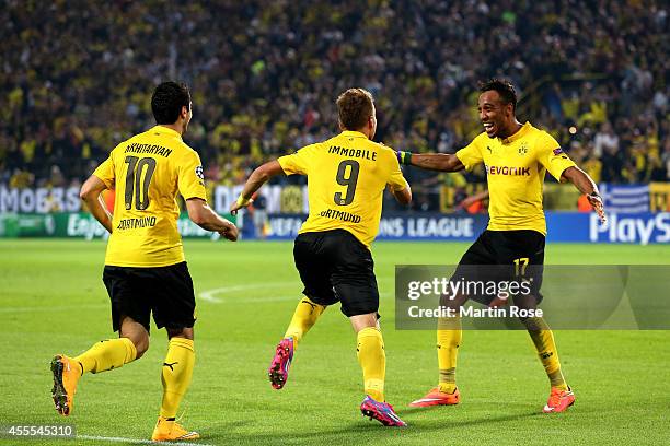 Ciro Immobile of Borussia Dortmund is congratulated by teammates Henrikh Mkhitaryan and Pierre-Emerick Aubameyang of Borussia Dortmund after scoring...