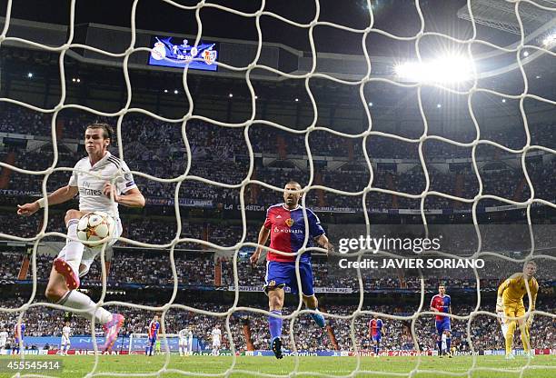 Real Madrid's Welsh forward Gareth Bale scores past Basel's Argentinian defender Walter Samuel and Basel's goalkeeper Tomas Vaclik during the UEFA...