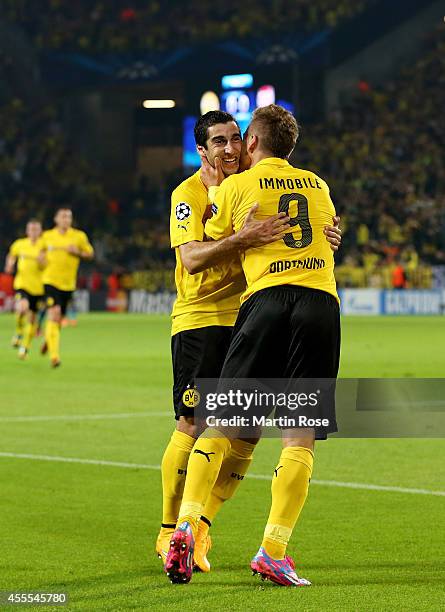 Ciro Immobile of Borussia Dortmund is congratulated by teammate Henrikh Mkhitaryan of Borussia Dortmund after scoring the opening goal on the stroke...