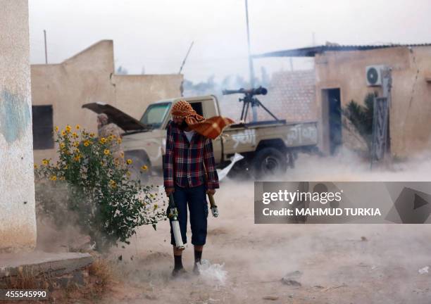 Members of the Shield Brigade, backed by some local fighters from the western region, fire an anti-tank cannon mounted on a pick-up truck during...