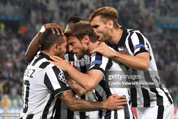 Carlos Tevez of Juventus celebrates the opening goal with team-mates Claudio Marchisio during the UEFA Champions League Group A match between...