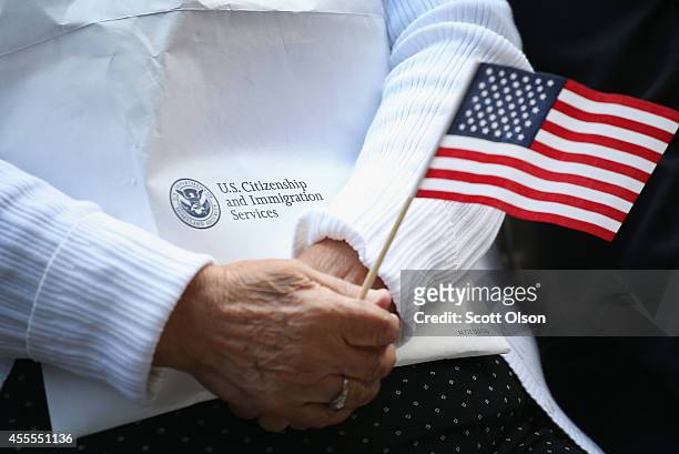 Immigrants from 25 countries participate in a naturalization ceremony in Daley Plaza on September 16, 2014 in Chicago, Illinois. Seventy people were...