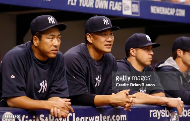 Hiroki Kuroda , Masahiro Tanaka and Mark Teixeira look on from the dugout before the start of a game against the Tampa Bay Rays on September 16, 2014...