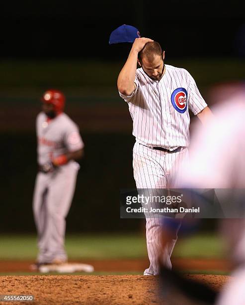 Starting pitcher Jake Arrieta of the Chicago Cubs reacts after giving up a double in the 8th inning to Brandon Phillips of the Cincinnati Reds to end...