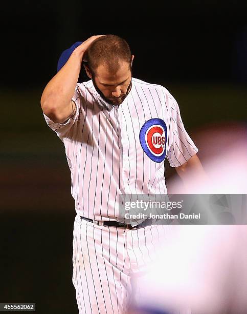 Starting pitcher Jake Arrieta of the Chicago Cubs reacts after giving up a double in the 8th inning to Brandon Phillips of the Cincinnati Reds to end...