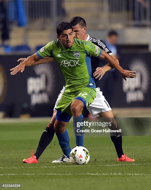 Defender Leo Gonzalez of the Seattle Sounders FC controls the ball in front of forward Sebastien Le Toux of the Philadelphia Union during the 2014...