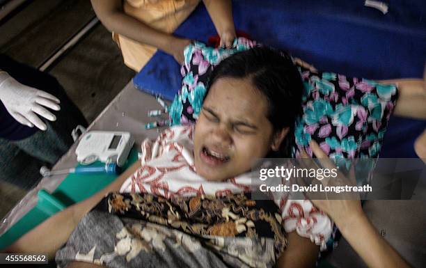 An ethnic Karen refugee mother gives birth to her first child at a makeshift clinic operated by mid wives at the Mae La refugee camp along the...