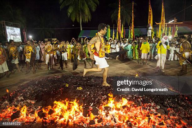 Devotees walk across hot coals at the Chinese shrine of Tae Gun Tae Tai during the annual Vegetarian Festival in Phuket, Thailand, Saturday, Oct. 12,...