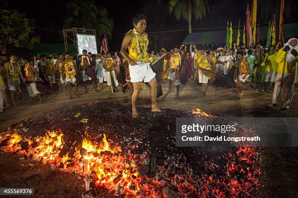 Devotees walk across hot coals at the Chinese shrine of Tae Gun Tae Tai during the annual Vegetarian Festival in Phuket, Thailand. The traditional...