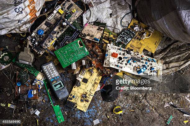 Motherboards and circuit boards sit among electronic waste strewn across the ground at a family compound of houses in Sangrampur village, West...