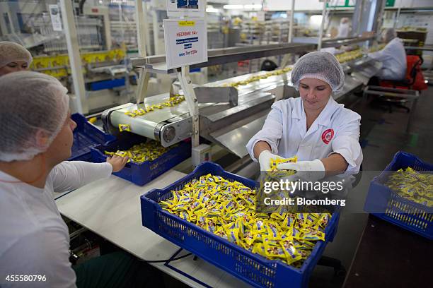 Worker loads a crate with packets of Nesquik countlines confectionary at the end of the production line in the Rossiya chocolate factory, operated by...