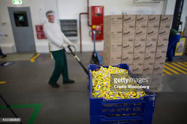 Worker pulls a pallet loaded with Nesquik boxes past a crate of Nesquik countlines confectionary in a distribution area at the Rossiya chocolate...