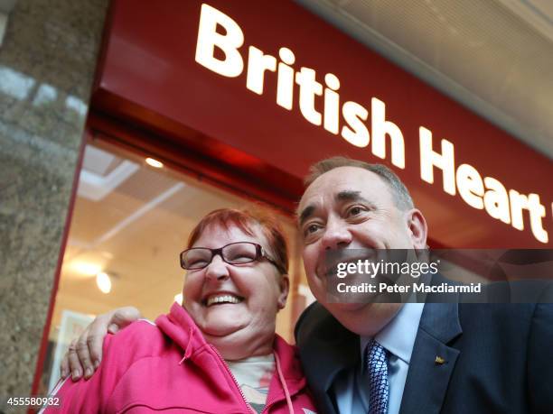 Scotland's First Minister Alex Salmond poses for a phone photo with a voter outside the British Heart Foundation charity shop in the East Kilbride...