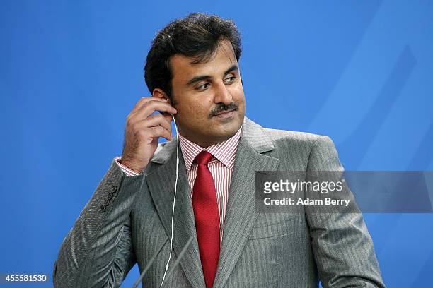 Sheikh Tamim bin Hamad Al Thani, the eighth and current Emir of the State of Qatar, listens during a press conference with German Chancellor Angela...
