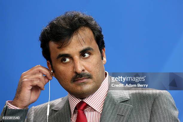 Sheikh Tamim bin Hamad Al Thani, the eighth and current Emir of the State of Qatar, listens during a press conference with German Chancellor Angela...