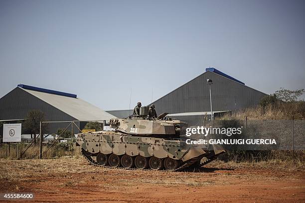 South African military personnel sit on top of an armoured vehicle during an exhibition at the Africa Aerospace and Defence 2014 fair at the...