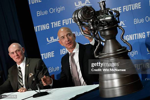 Jeff Bezos , the founder of Blue Origin and Amazon.com, gestures toward a model of the BE-4 rocket engine during a press conference with Tory Bruno ,...