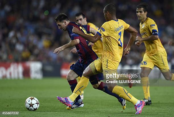 Barcelona's Argentinian forward Lionel Messi vies with Apoel's Brazilian defender Joao Guilherme during the UEFA Champions League football match FC...