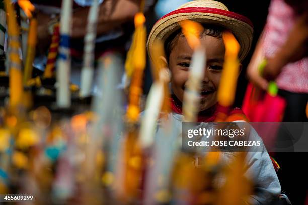 Child light candles to the Virgin at the Basilica de Guadalupe church in San Salvador, El Salvador on December 12, 2014 during the celebration of the...