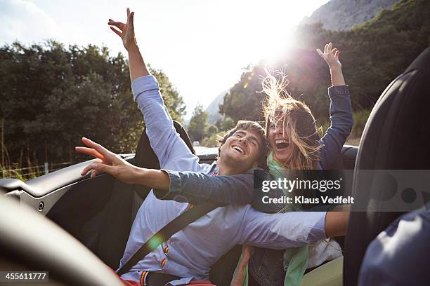 young couple riding car, wind in hair - happy couple car fotografías e imágenes de stock