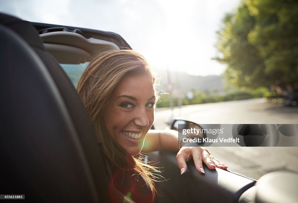 Portrait of laughing woman sitting in car