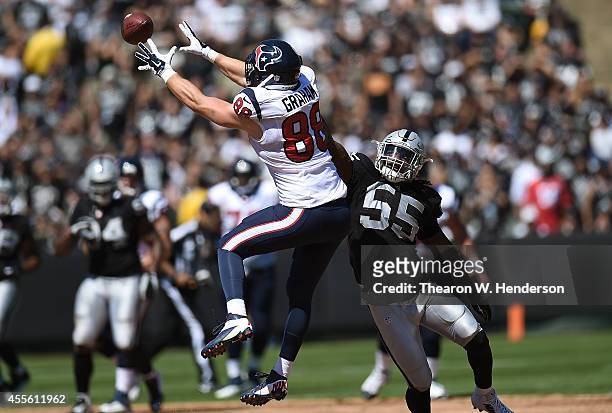 Garrett Graham of the Houston Texans catches a pass for a first down while defended by Sio Moore of the Oakland Raiders during the first quarter at...