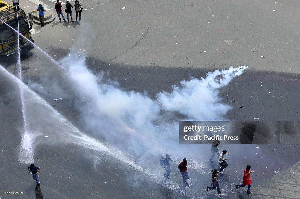 Police lob tear gas and shoot water from water cannons to...