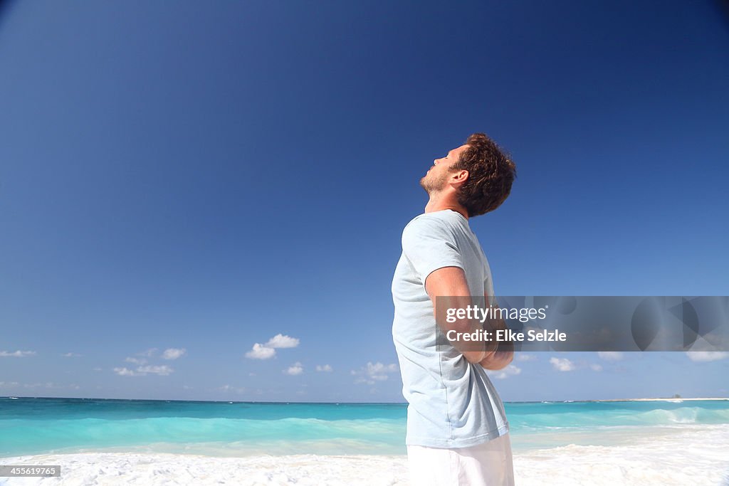 Man doing yoga on beach