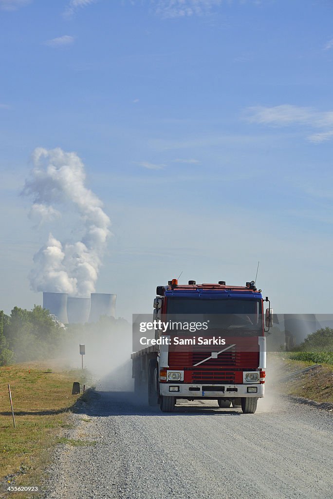 Speeding truck on dirt by nuclear power plant