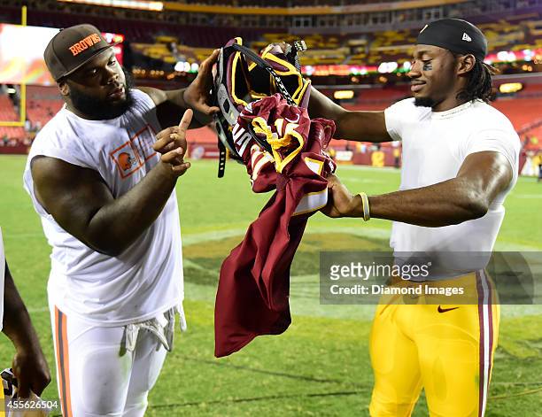 Defensive linemen Phil Taylor of the Cleveland Browns and quarterback Robert Griffin III of the Washington Redskins exchange jerseys after a game...