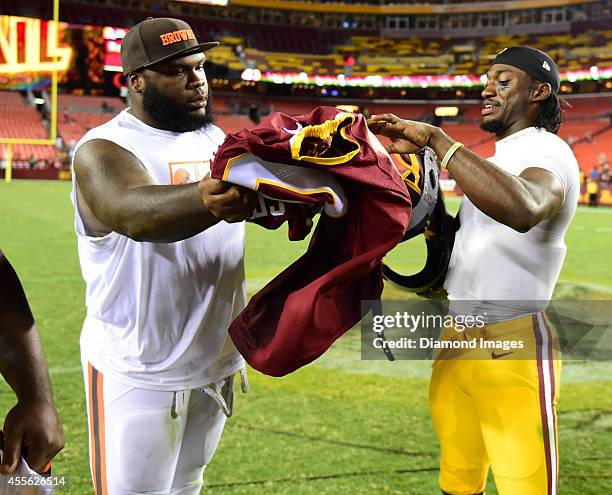 Defensive linemen Phil Taylor of the Cleveland Browns and quarterback Robert Griffin III of the Washington Redskins exchange jerseys after a game...